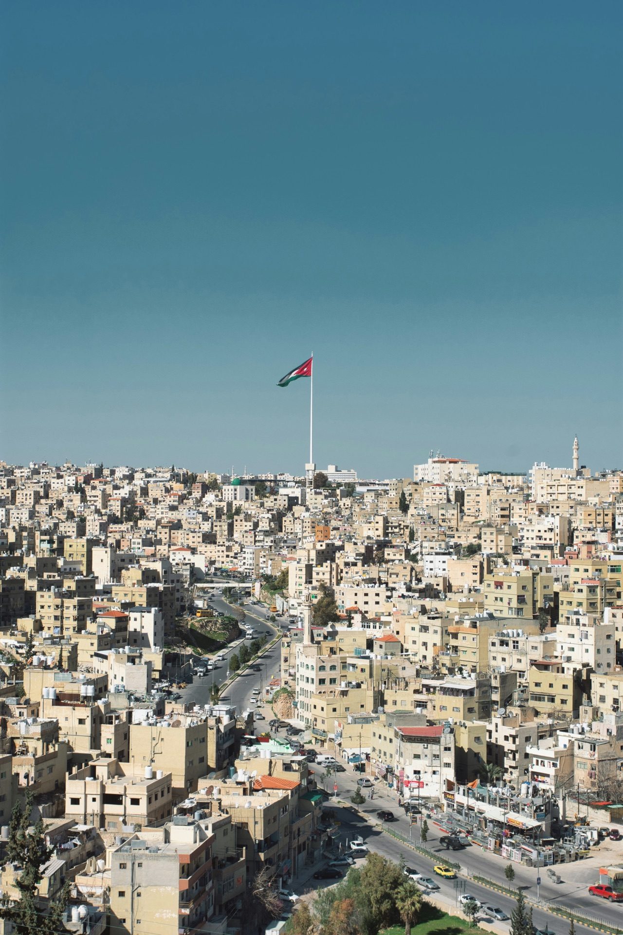 The skyline of modern Amman at dusk, hills covered in pale stone buildings