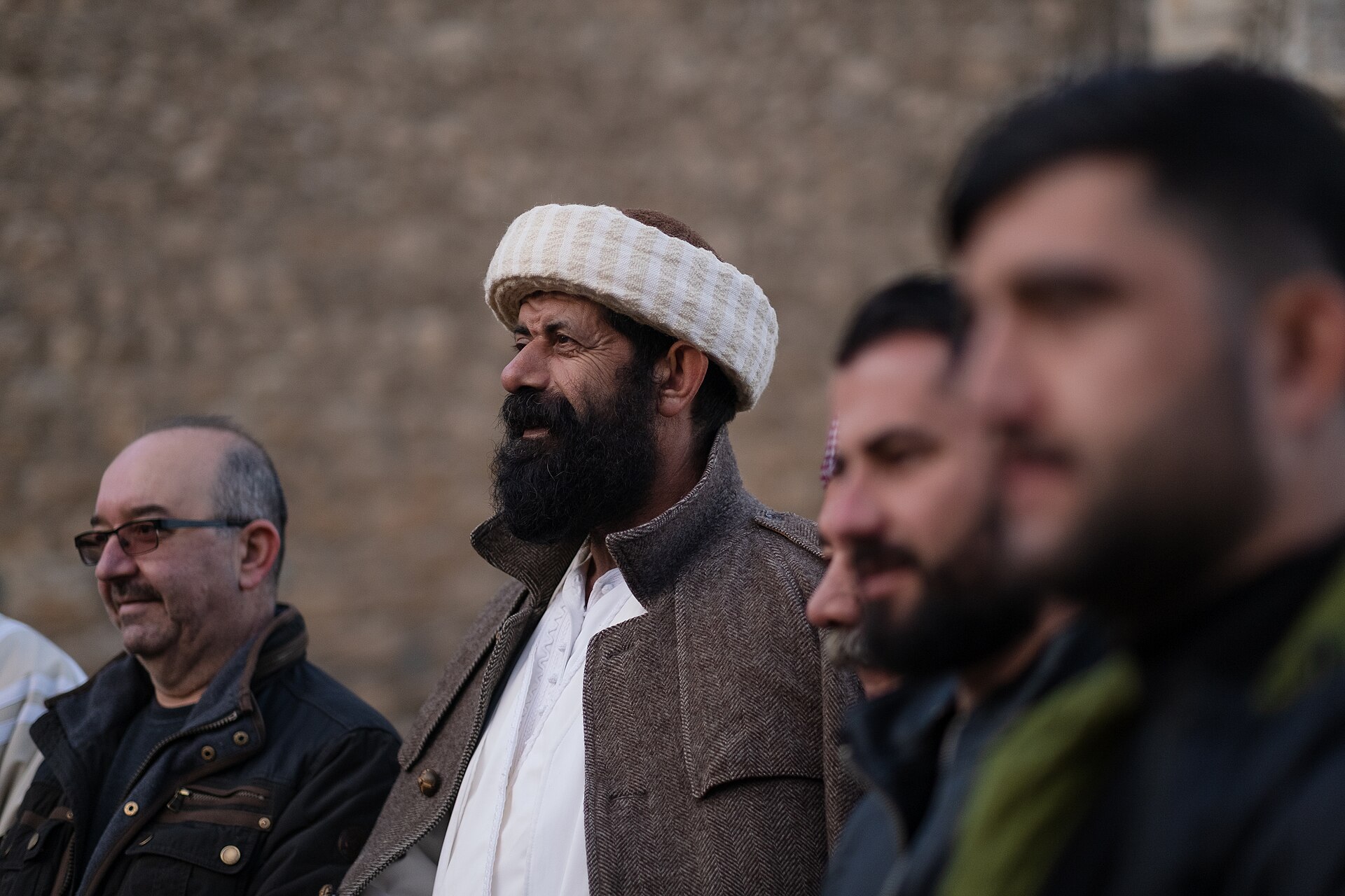 A Yazidi priest in white robes seated at the sanctuary of Lalish